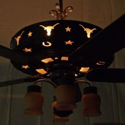 Night view showing the bottom housing illuminated and design cut outs around and under the fan.